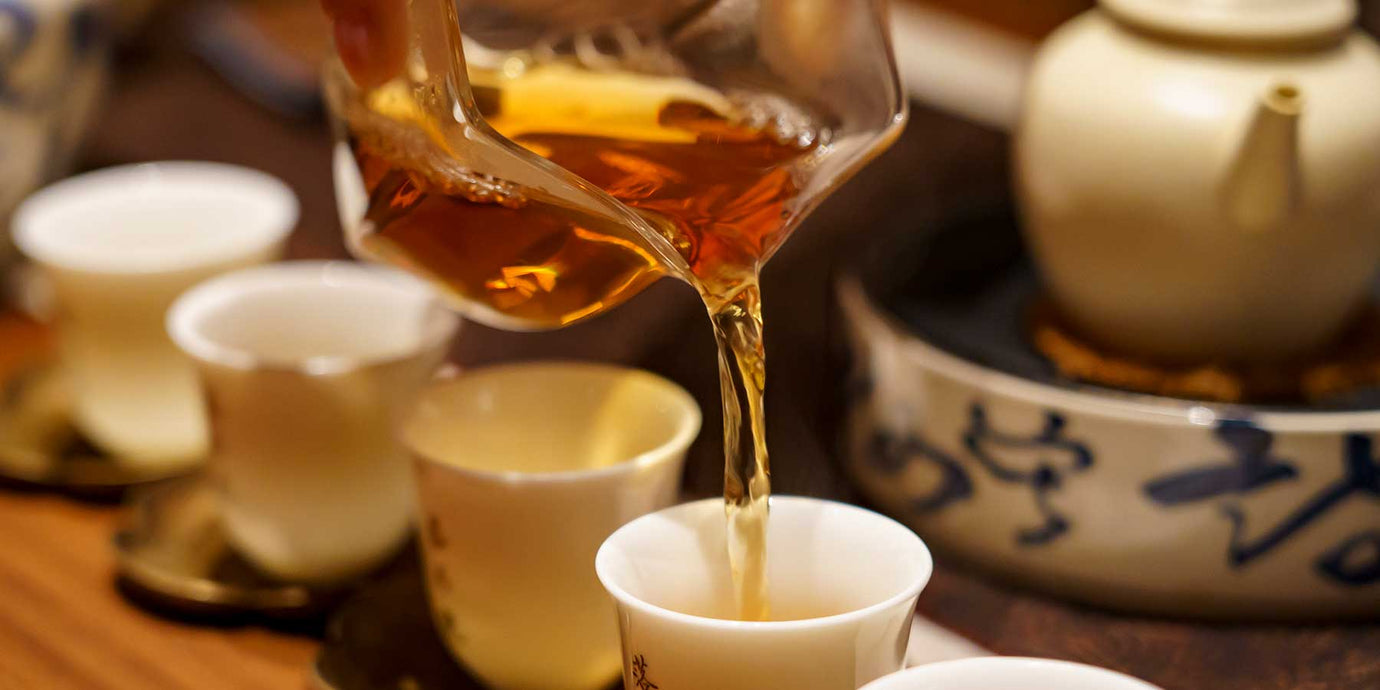 pouring oolong tea into small cups for tasting