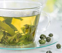 Cup of Jasmine Pearl Tea Opening in Water