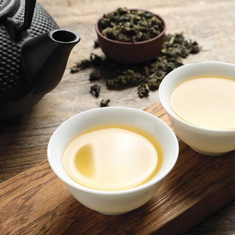 two cups of oolong milk tea with teapot